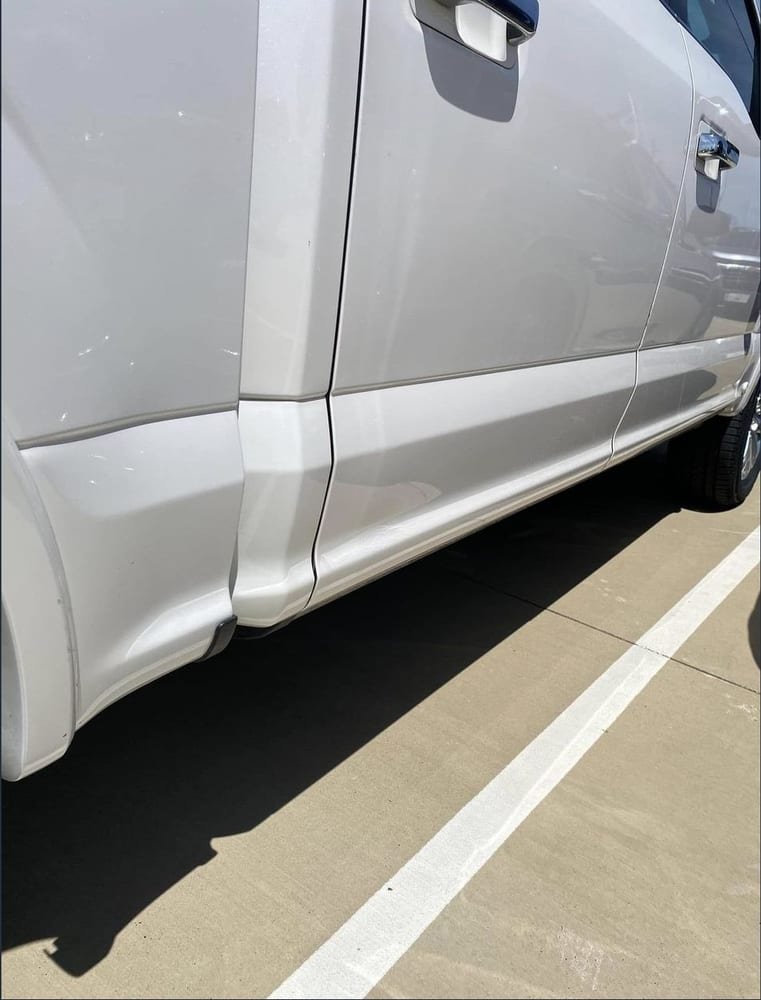 The same lower door panel after repair, dent fully removed