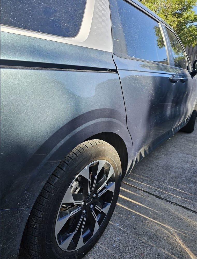 The same door and fender after repair and buffing, panel smooth with no scratches