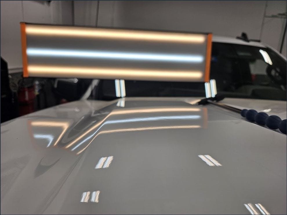 The same hood after repair, light board reflection running straight