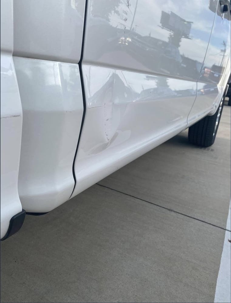 Creased lower door panel before paintless dent repair
