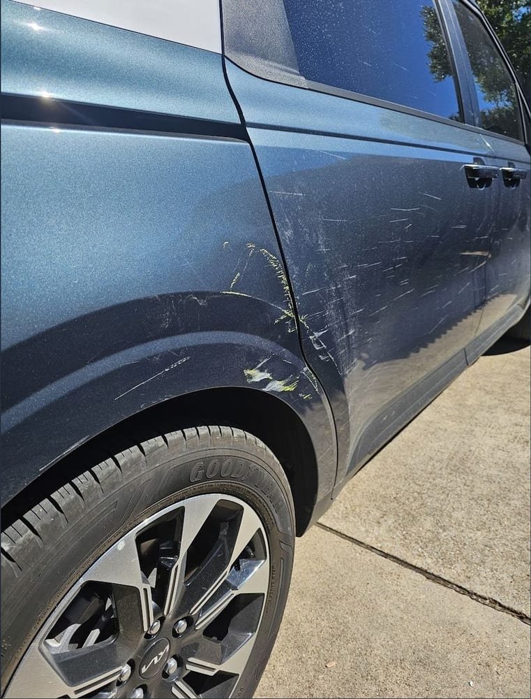 Dented door and fender before repair, with paint transfer scuffed across the panel
